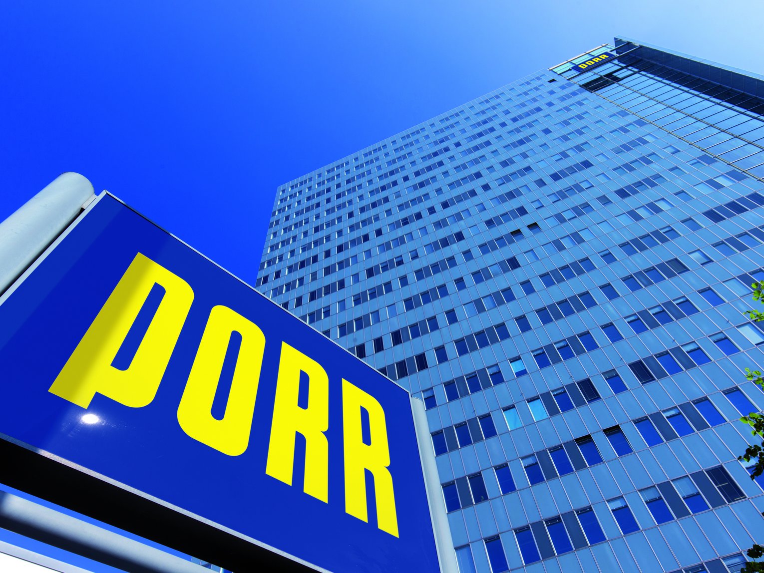 Blick von unten auf das Hochhaus der Firma PORR mit PORR Schild davor