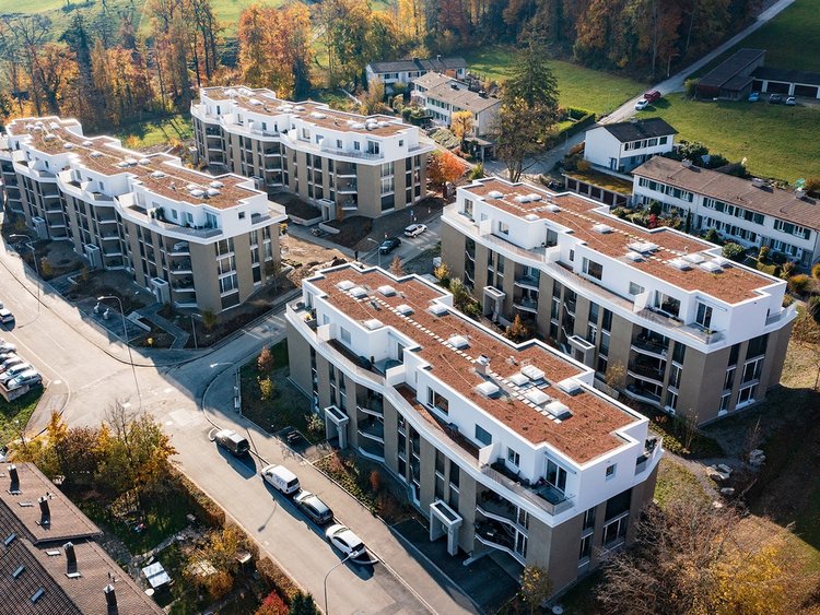 Photo: Drone shot of four newly built houses in context; other buildings, meadows and roads in the surrounding area